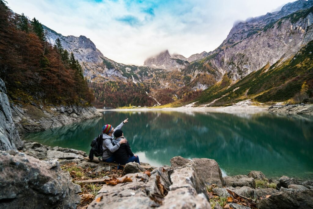 A couple enjoys a scenic view of Hallstatt Lake surrounded by mountains and fores.